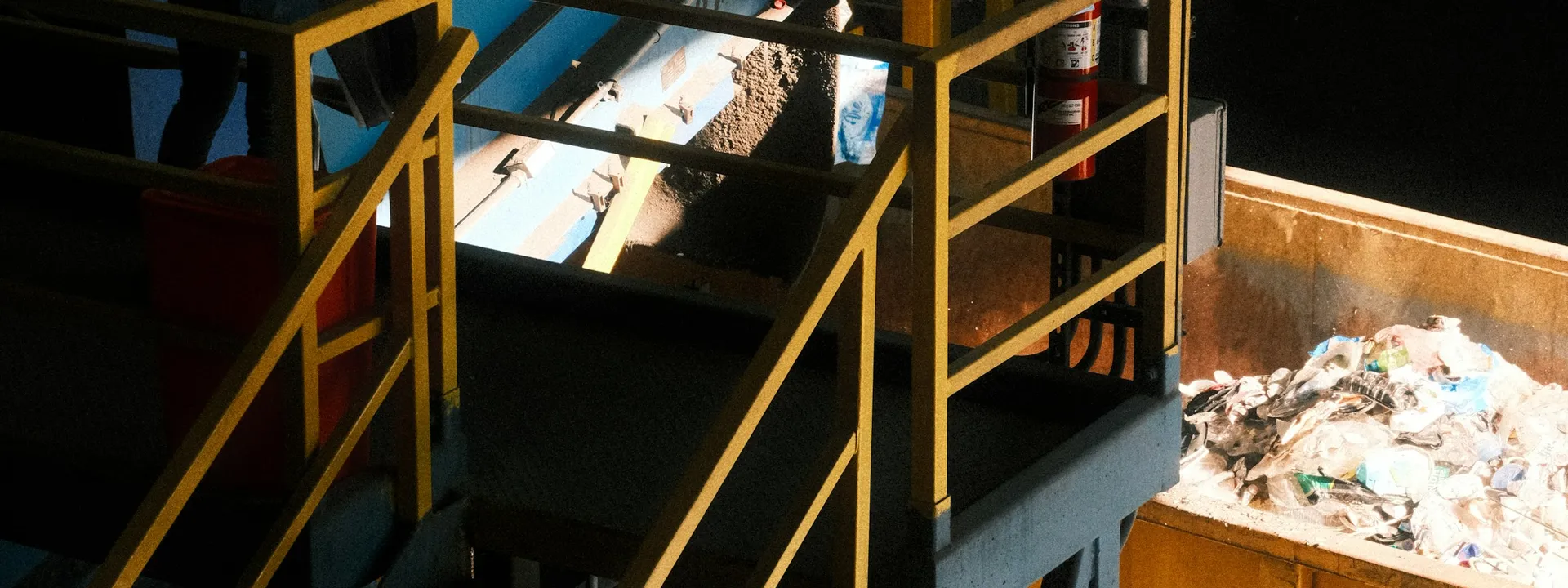 A recycling worker operating a material sorting conveyor